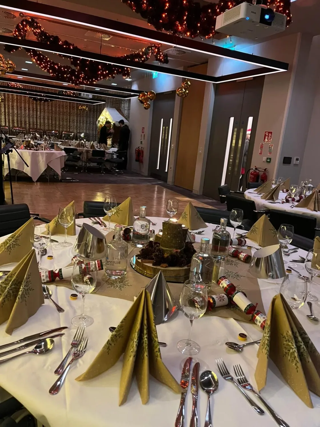 A dinner table set with gold-coloured party hats and glassware.