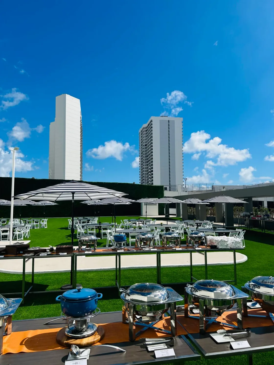 An outdoor terrace and landscaped grounds beneath two tall towers.
