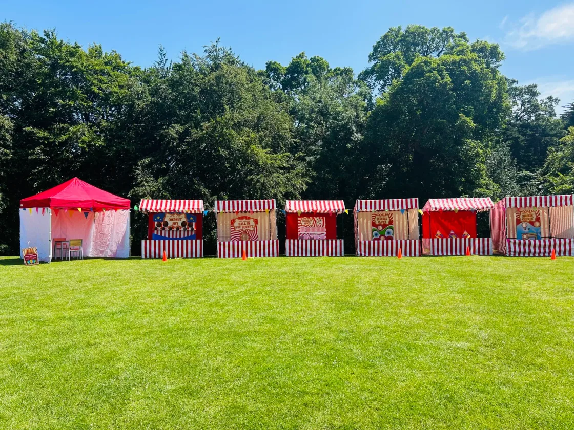 Red-and-white carnival games set out on the lawn for the Summer Celebration Carnival.