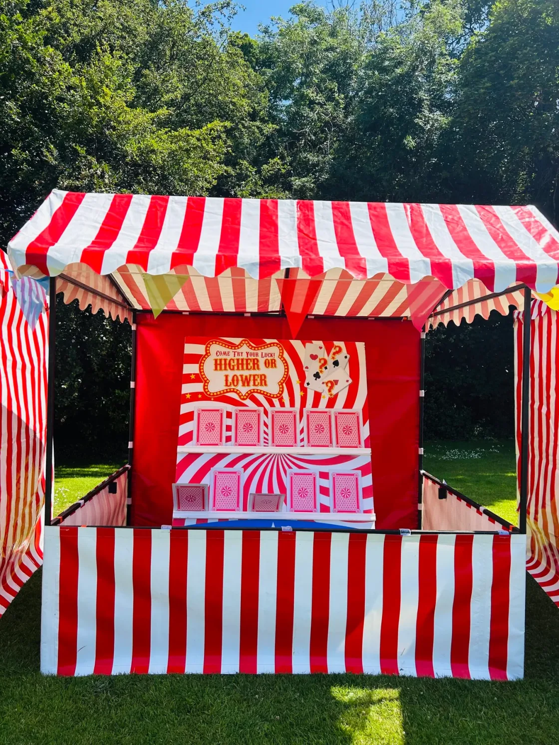 A red-and-white striped candyfloss stand on a lawn.