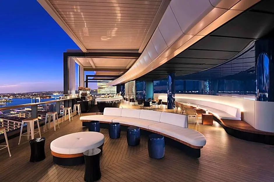 A curved outdoor terrace with lounge seating and views across the city.