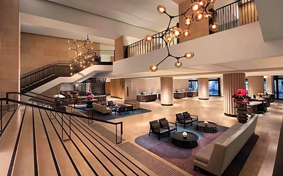 A contemporary hotel interior with open staircases, pendant lights and lounge seating.