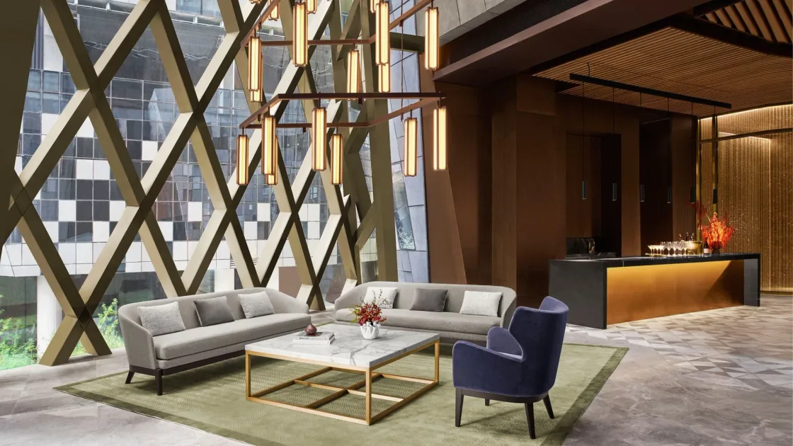Lounge seating beside tall windows and diagonal architectural supports.