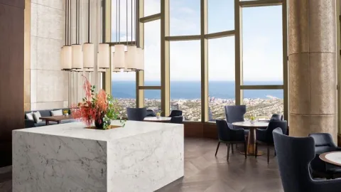 A floral display on a marble counter beside panoramic windows.