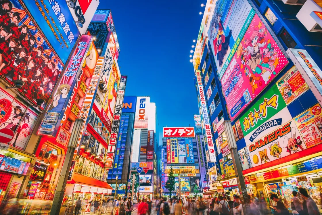 A city street lined with brightly coloured signs and tall buildings.