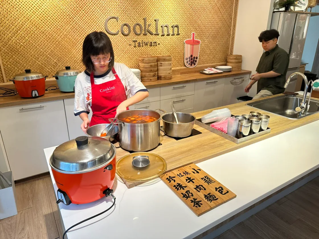 Guests taking part in a cookery class at a kitchen counter.