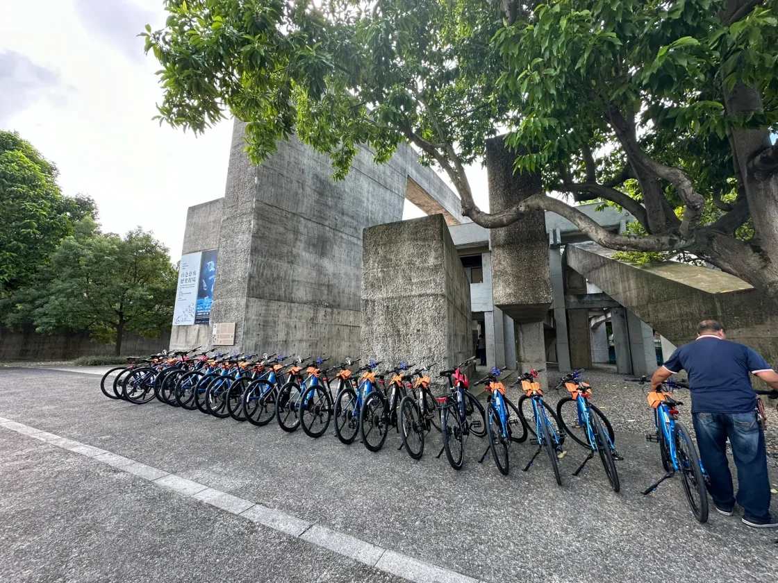 Bicycles lined up beside steps and a wooded entrance.