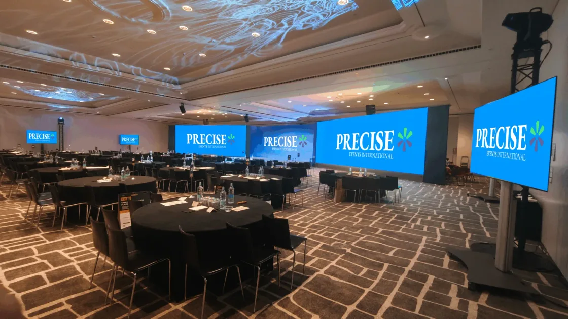 Conference tables facing a wide PRECISE presentation screen.