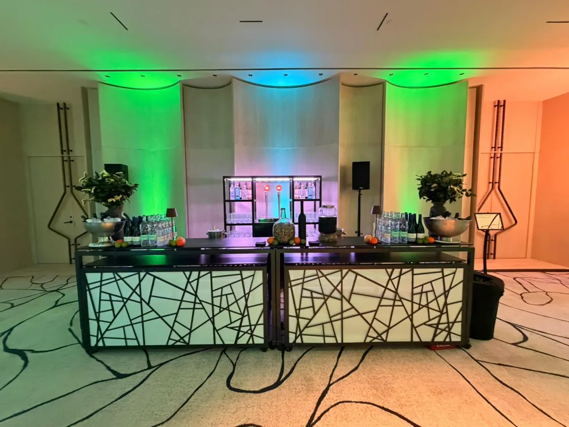 A hospitality bar lit in green and violet at the Barcelona Sales Conference.