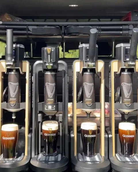 Glasses of Guinness being poured at a tasting station.