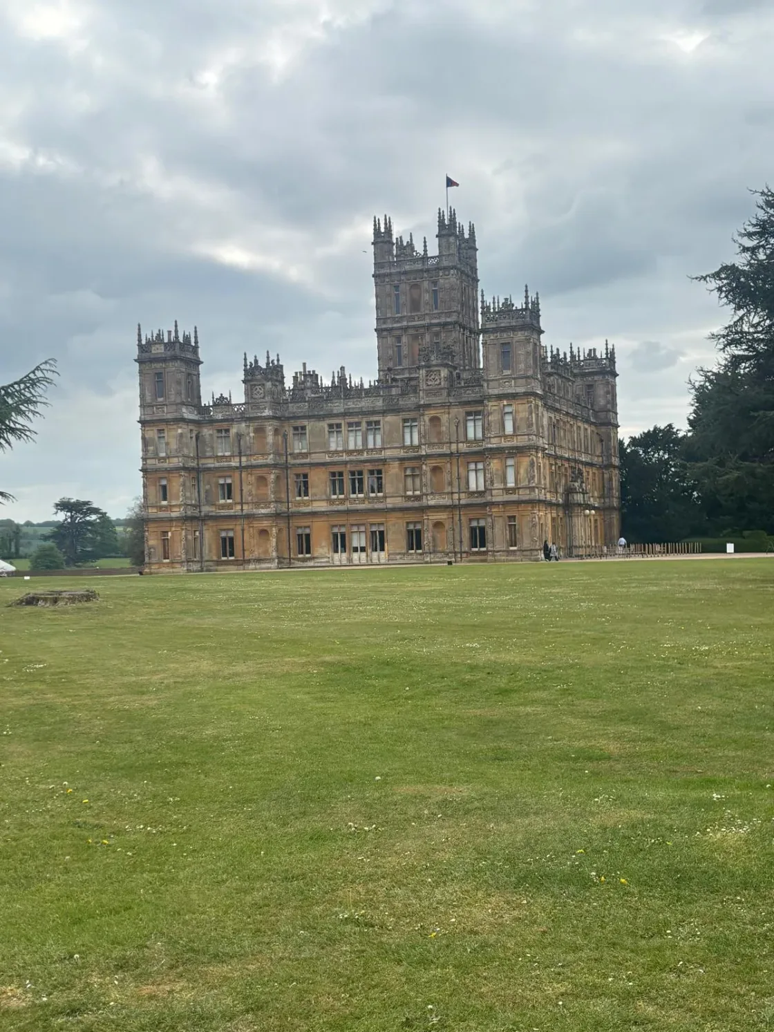 A large stone castle overlooking a broad lawn.