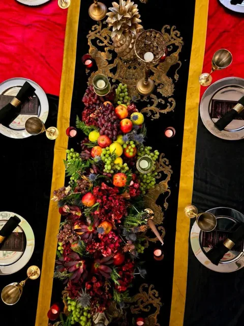 Overhead view of a banquet table with fruit displays, candles and place settings.