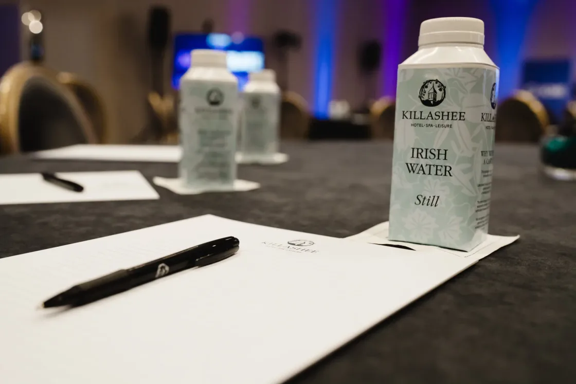 Cartons of water, notepads and pens arranged on conference tables.