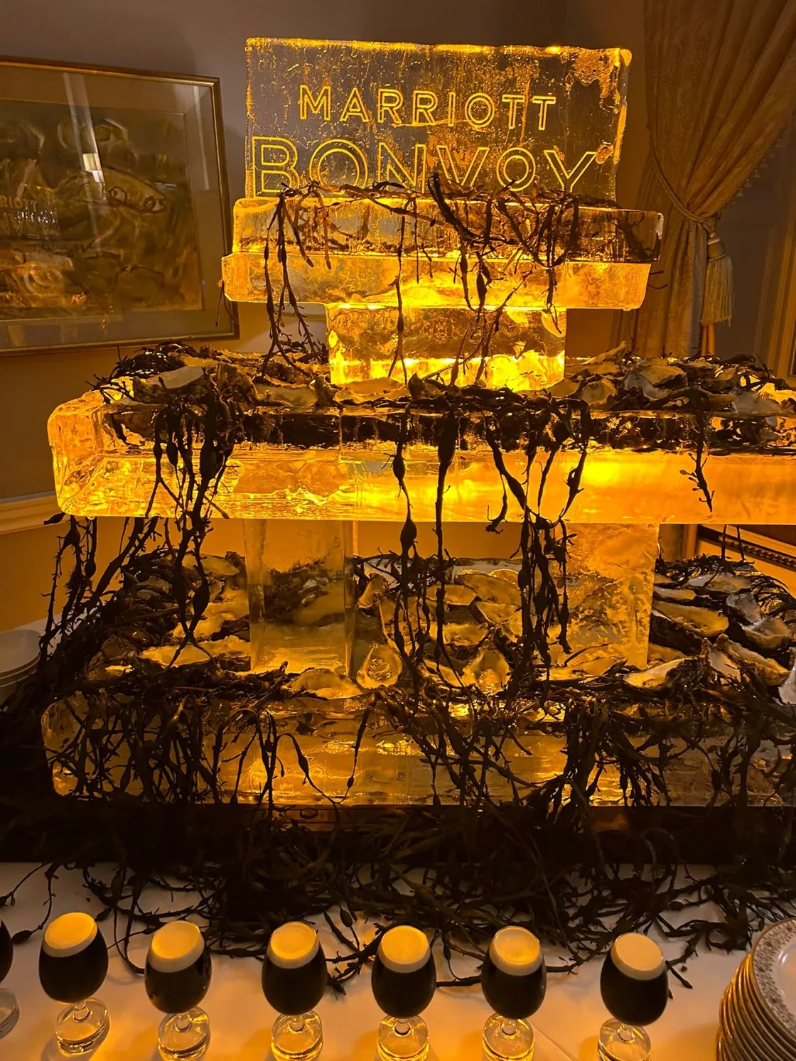 An illuminated ice sculpture displayed above rows of bottled drinks.