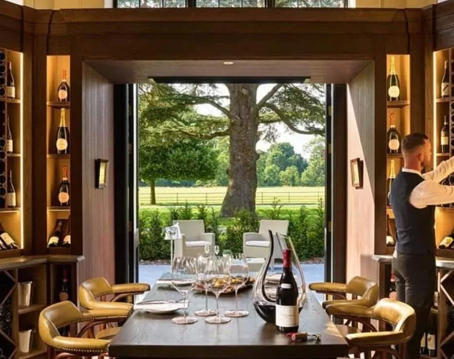 A dining table beside an open doorway looking out onto a garden.