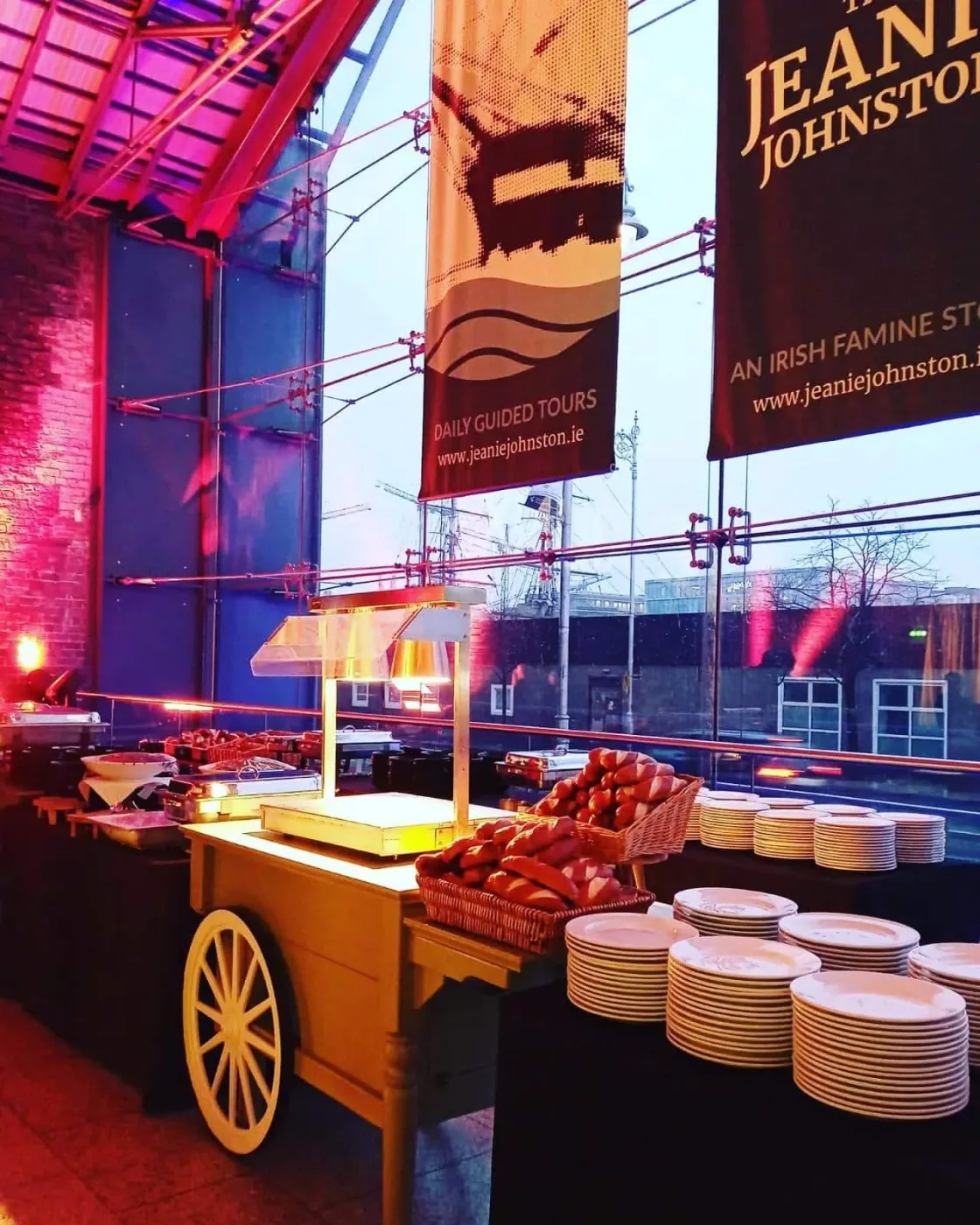 A food-service counter inside a brightly lit glass-roofed venue.
