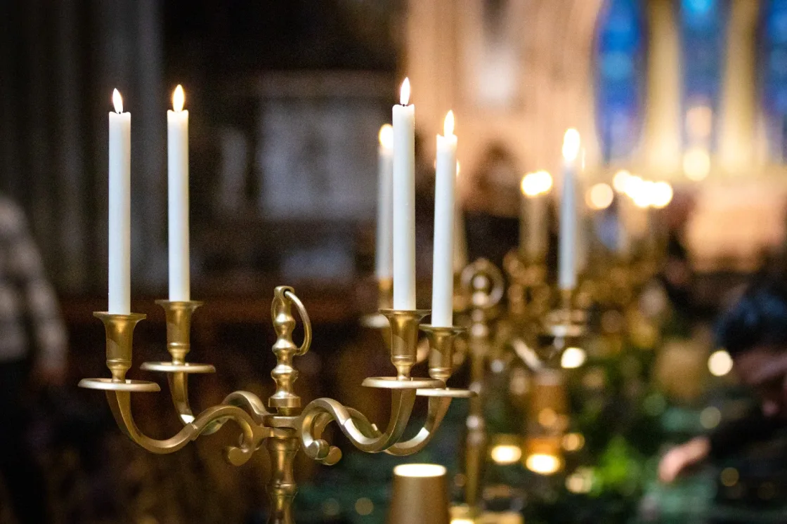 White candles burning in a gold-coloured candelabrum.