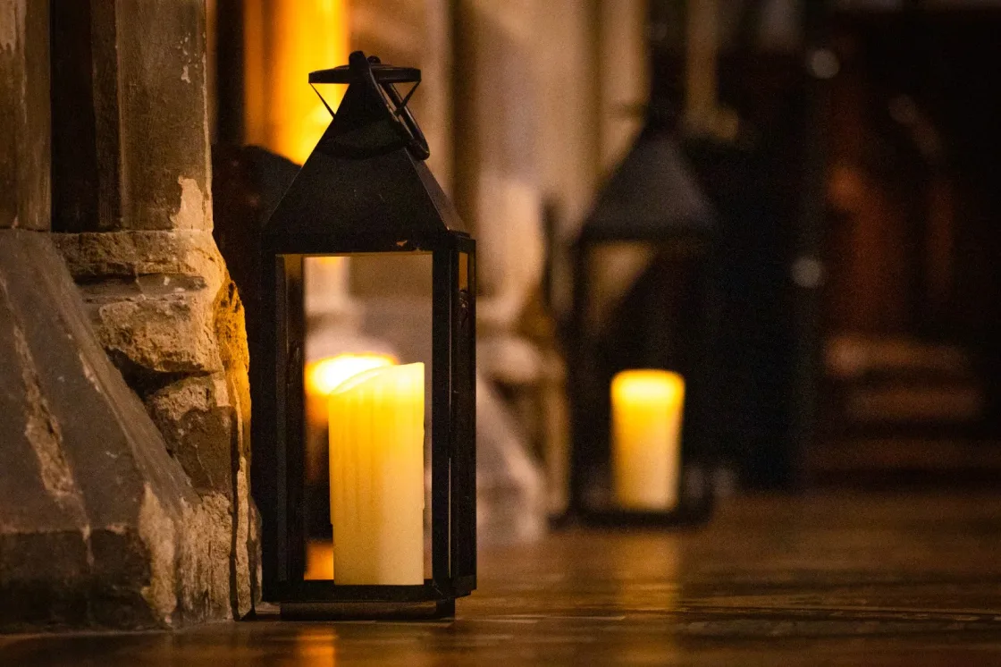 Candle lanterns on stone steps inside a historic building.