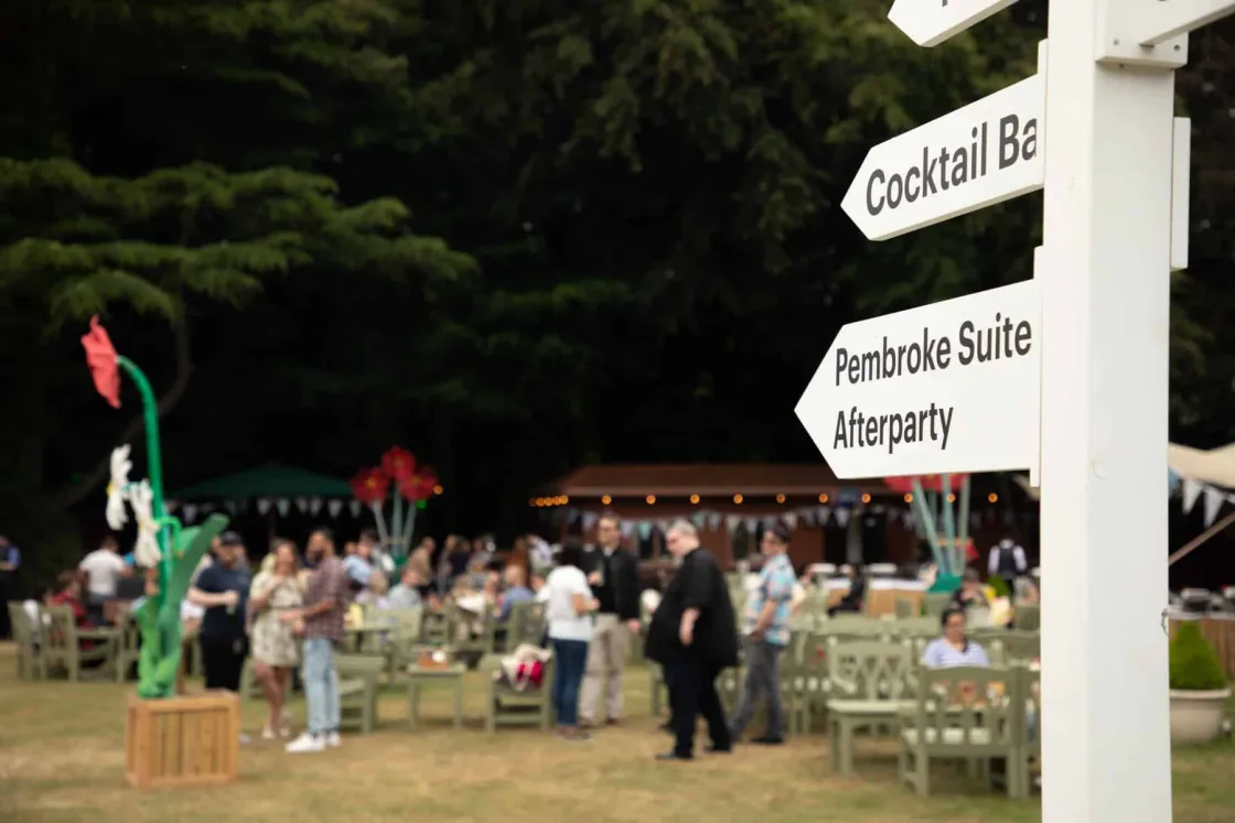 A directional sign pointing guests towards the cocktail bar and afterparty.