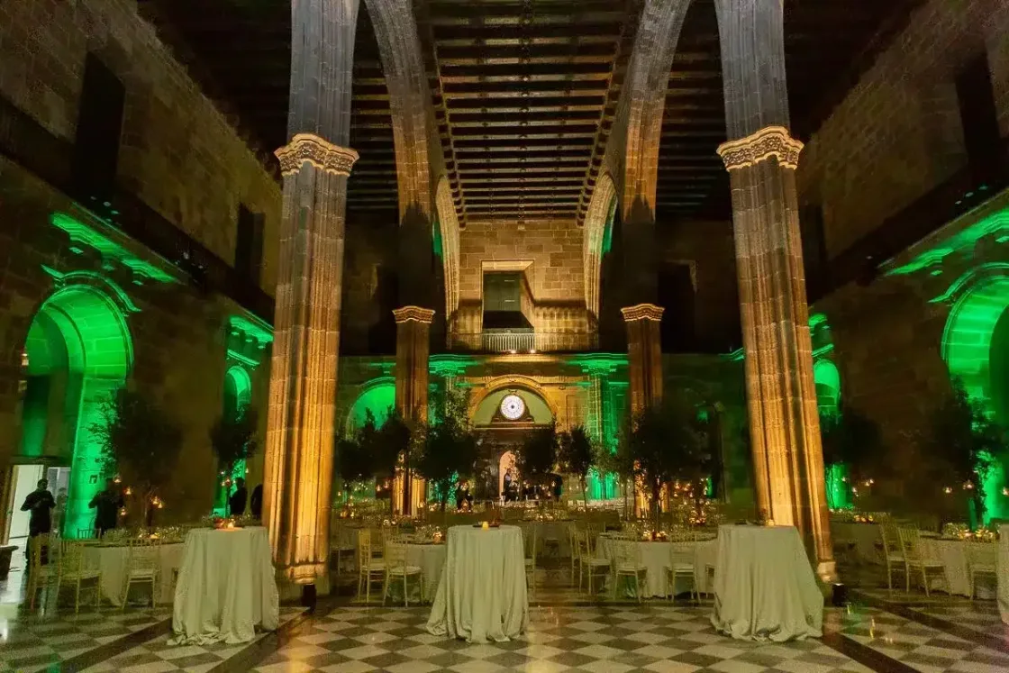 A columned dining hall illuminated in green.