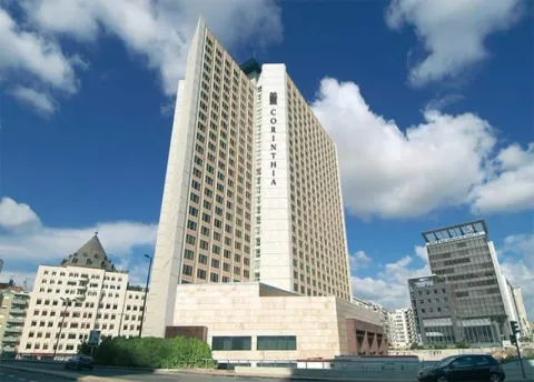 A tall white hotel tower against a blue sky.