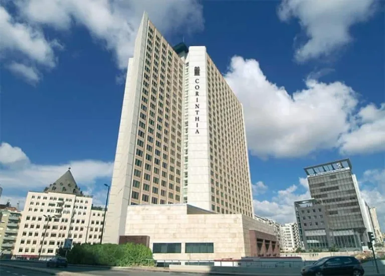 A tall white hotel tower against a blue sky.