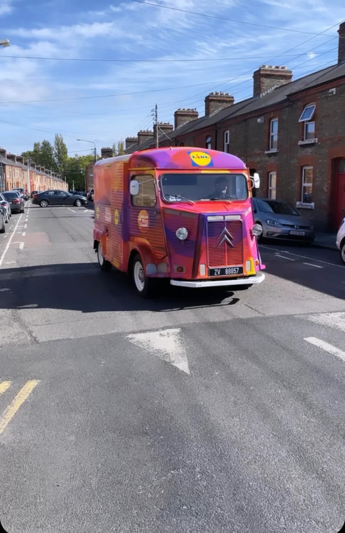A colourful catering van parked on a street.