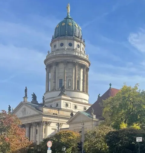 A domed stone tower rising above a city street.