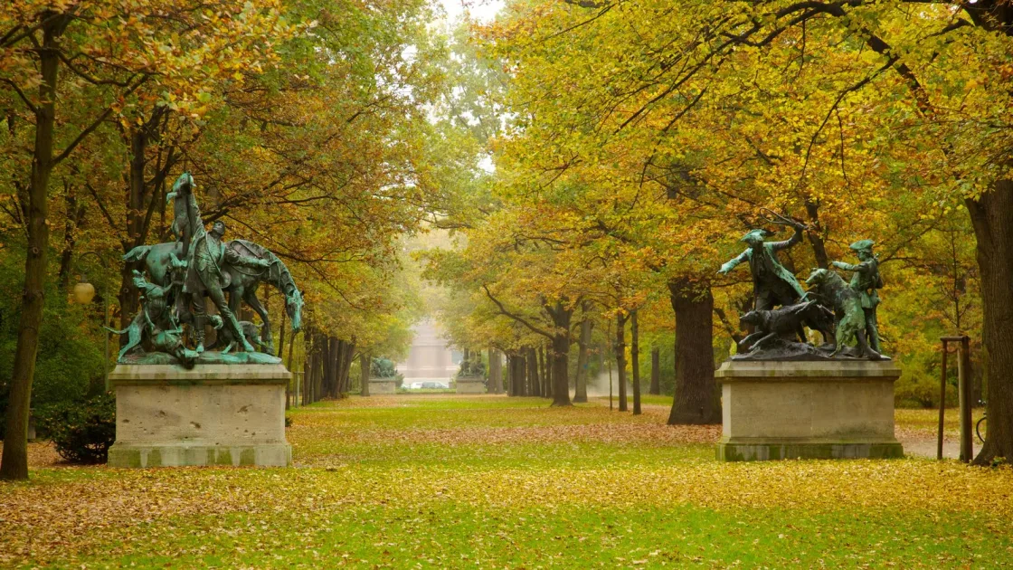 An autumn avenue lined with trees and equestrian sculptures.