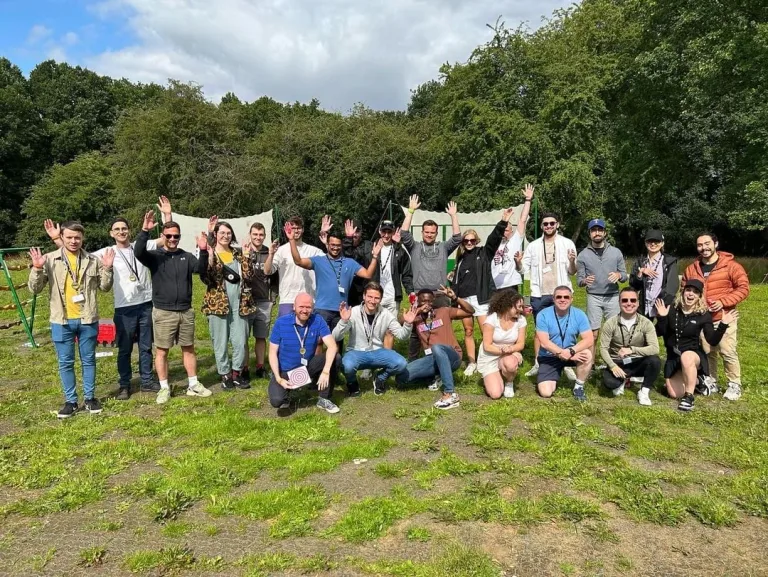 A group posing on a grassy hillside beside stone walls.