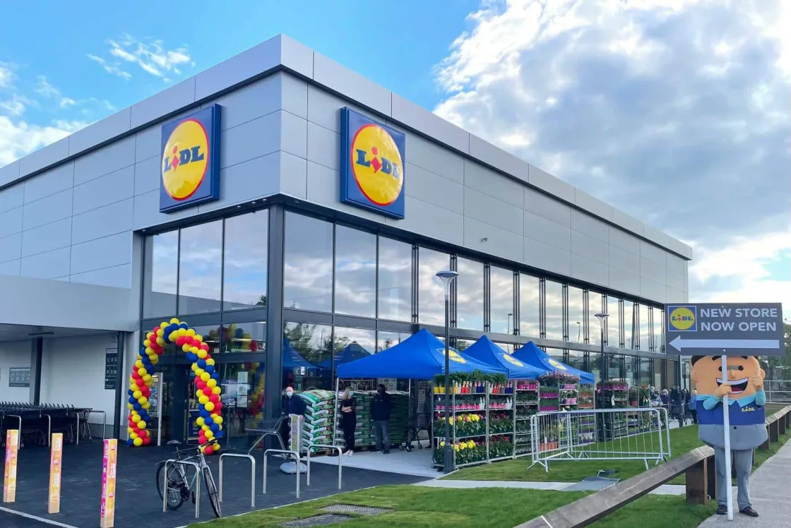 Lidl store entrance decorated with a balloon arch and outdoor tents.