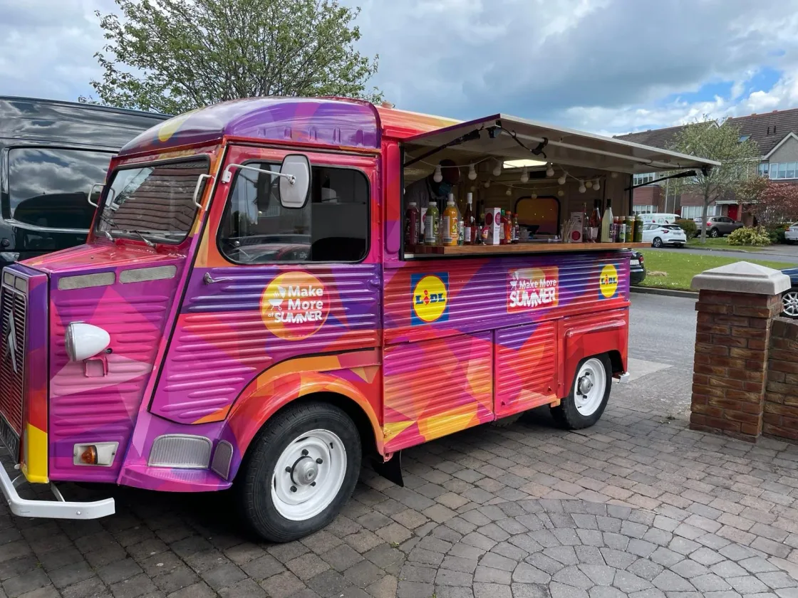 A pink catering van with an open serving hatch.